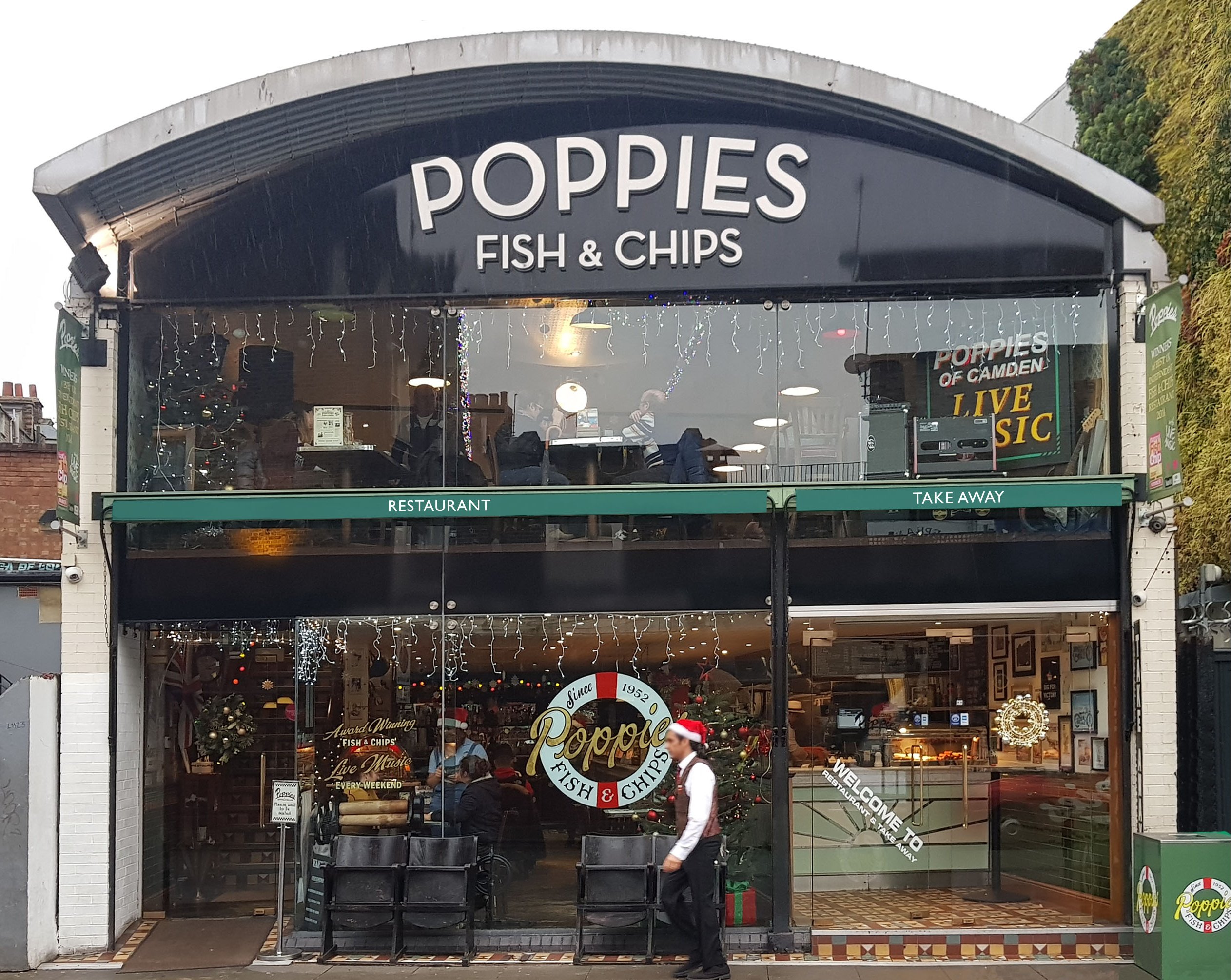 These two excellent  Victorian awnings, installed at Poppies Fish and Chips in Camden were particularly challenging for us due to the expanse of glass on this frontage we and the lack of obvious fixings. However using imagination and a combination of fixing brackets the task was successfully achieved as can be seen on the images alongside.  The soil and UV resistant fabric selected was a forest green colour and the complex logo and graphics was picked out in a contrasting colour using our bespoke RAGS® bran